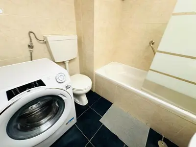 a bathroom with a washing machine and a toilet at Apartamento albufeira T1 condominio vila nova in Albufeira