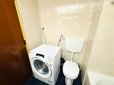 a bathroom with a washing machine and a toilet at Apartamento albufeira T1 condominio vila nova in Albufeira