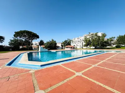 a swimming pool in the middle of a building at Apartamento albufeira T1 condominio vila nova in Albufeira
