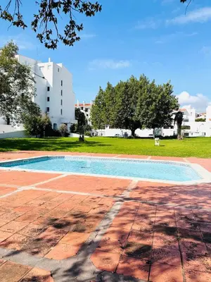 an empty swimming pool with a building in the background at Condominio privado T1 Rua da Oura in Albufeira