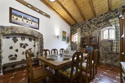 a dining room with a table and a stone fireplace at Villa Monte Domingos Simoes in Albufeira