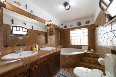 a bathroom with two sinks and two mirrors at Villa Monte Domingos Simoes in Albufeira