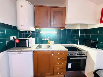 a small kitchen with a sink and a microwave at Condominio vila nova T1 Rua da Oura in Albufeira