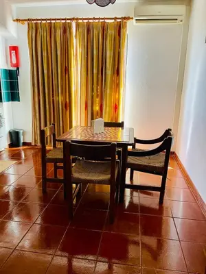 a table and chairs in a room with a window at Resort Albufeira T1, Oura Beach in Albufeira