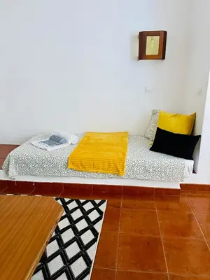 a bed with a yellow blanket on it in a room at Resort Albufeira T1, Oura Beach in Albufeira