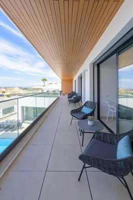 a balcony with chairs and a pool on a building at Villa Clipper in Guia