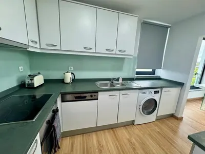 a kitchen with a sink and a washing machine at Sundown Pines Vilamoura in Quarteira