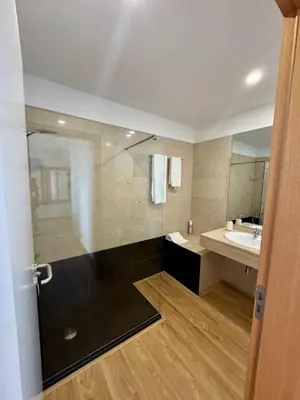 a bathroom with a shower and a sink and a mirror at Sundown Pines Vilamoura in Quarteira