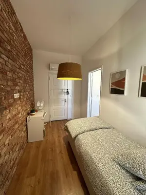 a bedroom with a bed and a brick wall at Casa das Oliveiras in Faro