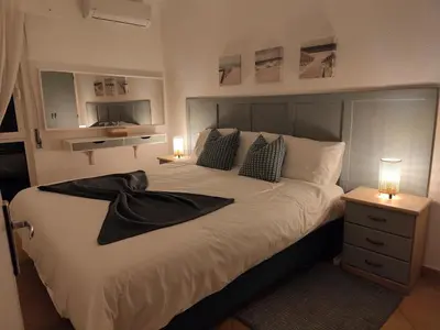 a bedroom with a large bed with a black robe on it at Boa Vida in Vilamoura