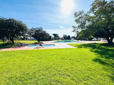 a group of people standing around a swimming pool in a park at Resort Albufeira T1, Oura Beach in Albufeira