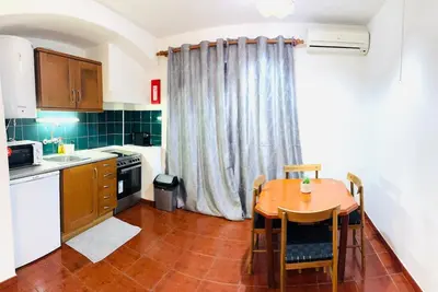 a kitchen with a wooden table and a kitchen with a table and chairs at Studio Vila Nova in Albufeira