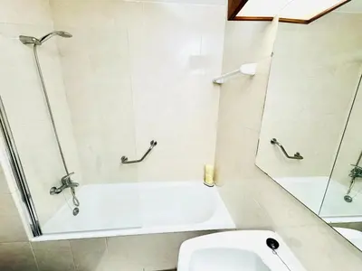 a bathroom with a shower and a toilet and a mirror at Resort Albufeira T2, Oura Beach in Albufeira