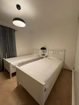two beds in a white room with a lamp at Lovely 3 Bedroom Home in a Resort in Albufeira in Albufeira