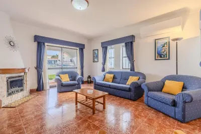 a living room with two blue couches and a fireplace at #350 Retiro do Abade by Home Holidays in Ferreiras