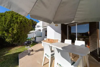 a patio with a table and chairs under an umbrella at My Inzu by HelloVacations in Albufeira