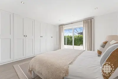 a bedroom with a bed with a lamp on a night stand at Villa Benjamin - Vale do Lobo in Vale do Lobo