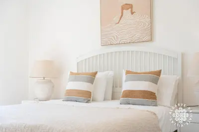 a bedroom with a bed and a chair and a window at Villa Benjamin - Vale do Lobo in Vale do Lobo