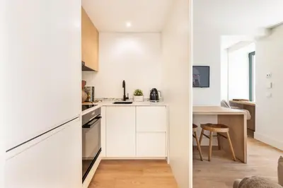 a small kitchen with white cabinets and a table at BLQ Charneco 1BDR in Boliqueime by LovelyStay in Boliqueime