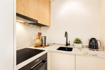 a small kitchen with white cabinets and a sink at BLQ Charneco 1BDR in Boliqueime by LovelyStay in Boliqueime