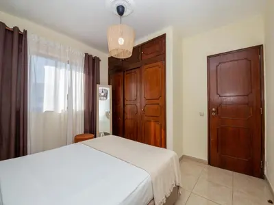 a bedroom with a white bed and a wooden door at Akisol Albufeira Orion in Albufeira