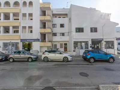 three cars parked in a parking lot in front of buildings at Akisol Albufeira Orion in Albufeira