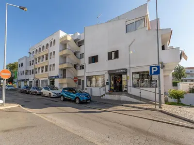 a parking lot with cars parked in front of a building at Akisol Albufeira Orion in Albufeira