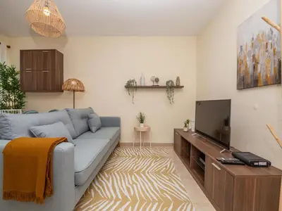 a living room with a blue couch and a tv at Akisol Albufeira Orion in Albufeira