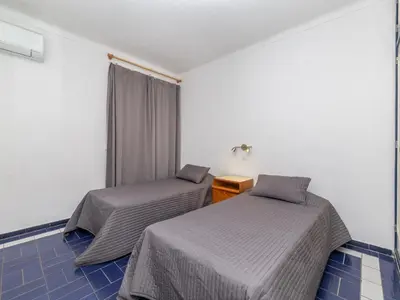 two beds in a room with blue tiles at Akisol Albufeira Eris in Albufeira