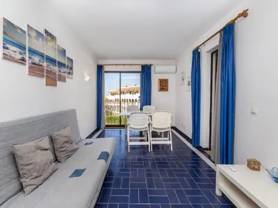 a living room with a couch and a table and chairs at Akisol Albufeira Eris in Albufeira