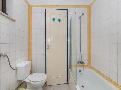 a bathroom with a toilet and a shower and a tub at Akisol Albufeira Eris in Albufeira