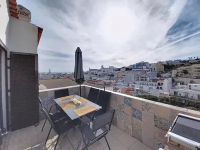 a balcony with a table and an umbrella at Panorama Old Town sea view Albufeira in Albufeira