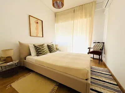 a bedroom with a bed with a chair and a window at Casa Nico in Faro