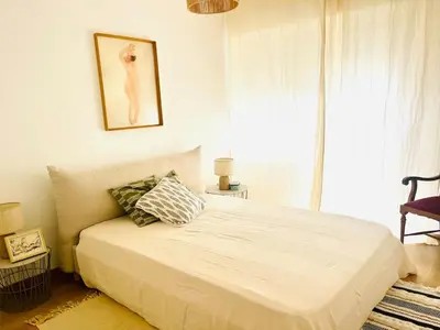 a bedroom with a white bed with a window at Casa Nico in Faro