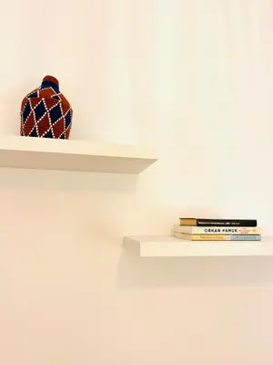 a vase sitting on a shelf with books at Casa Nico in Faro