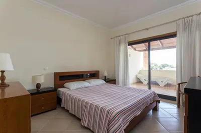 a bedroom with a bed and a sliding glass door at vista golf in Quarteira