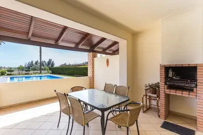 a patio with a table and chairs and a fireplace at vista golf in Quarteira