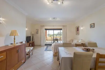 a living room with a table and a dining room at vista golf in Quarteira