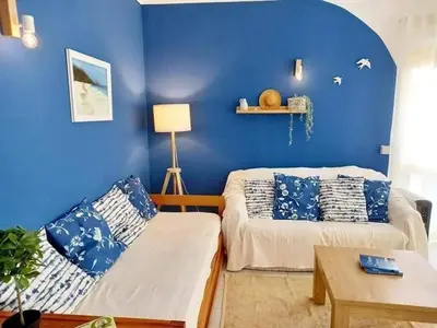 a blue room with two beds and a table at Casa de Praia dos Avós in Quarteira