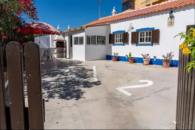 a parking lot with a fence and a building at Blife Lucelya private rooms at Faro beach in Faro