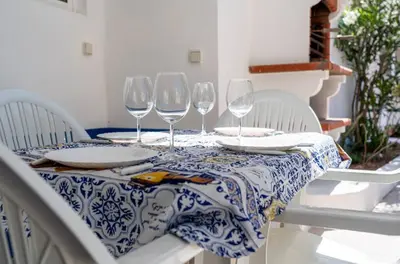 a table with wine glasses on a blue and white table cloth at Blife Lucelya private rooms at Faro beach in Faro