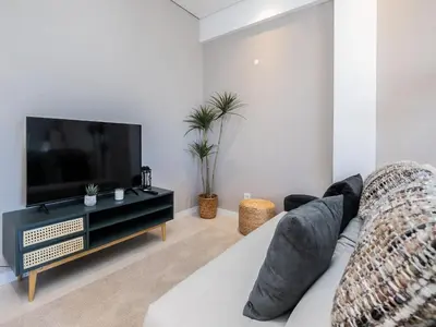 a living room with a couch and a flat screen tv at Akisol Vilamoura Iron in Quarteira