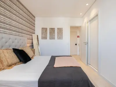 a bedroom with a large bed with a large headboard at Akisol Vilamoura Iron in Quarteira