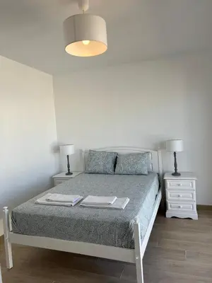 a bedroom with a bed with two night stands and two lamps at Quarteira Atlantic View in Sesmarias