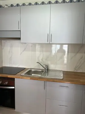 a kitchen with white cabinets and a sink at Quarteira Atlantic View in Sesmarias