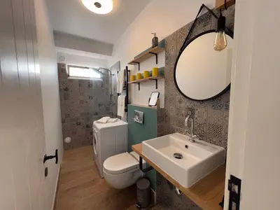 a bathroom with a sink and a toilet and a mirror at casa do cesar in Albufeira