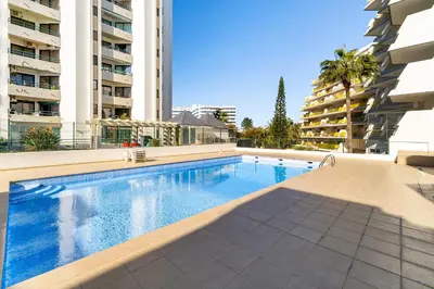 a swimming pool in the middle of a building at Marina Family Apartment - Pool & Garage in Vilamoura