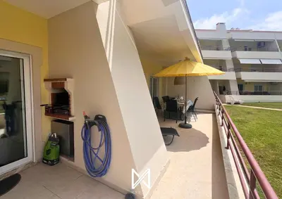 a balcony with a hose and an umbrella at MyStay - Farol Moura in Quarteira