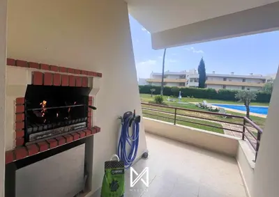 a balcony with a fireplace with a view of a pool at MyStay - Farol Moura in Quarteira