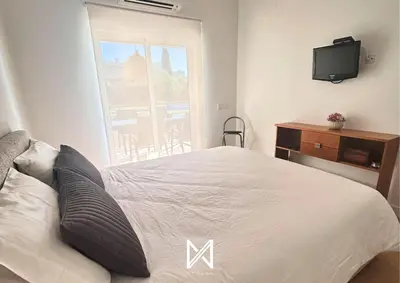 a bedroom with a bed and a tv and a window at MyStay - Farol Moura in Quarteira